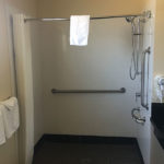 roll-in shower with grab bars in ADA accessible bathroom